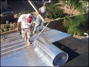 Roofers installing reflective underlaymwnt