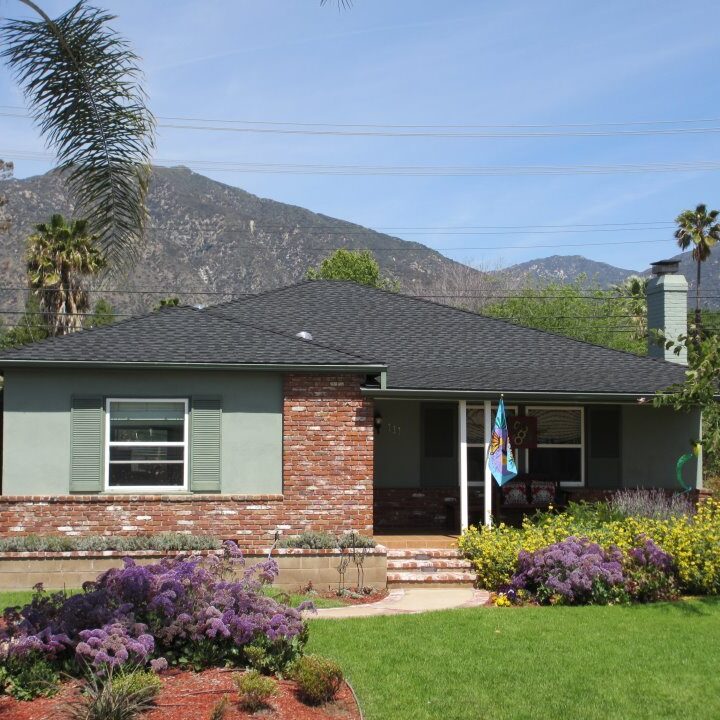 Home with black roof in front of mountains. Roof in foreground with mountains in background
