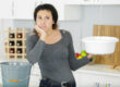 Woman holding bucket under leaking roof