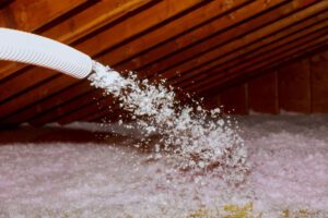 Fiberglass Insulation in the attic showing only the hose blowing the fiberglass.