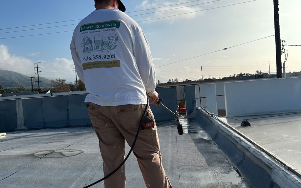 Worker holding a blow torch for commercial roof install.