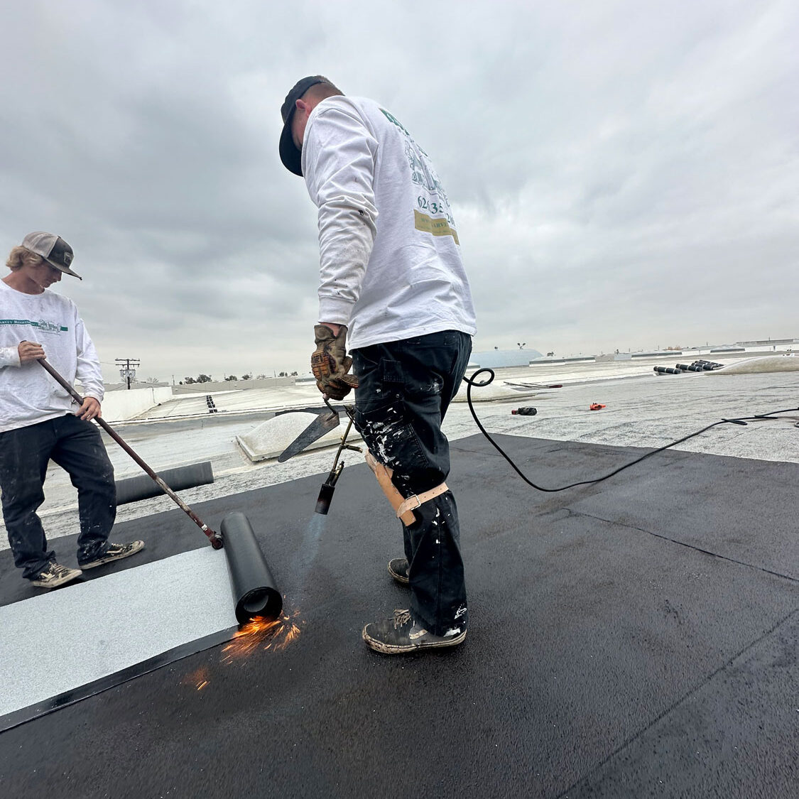 Commercial roof install using a blow torch.