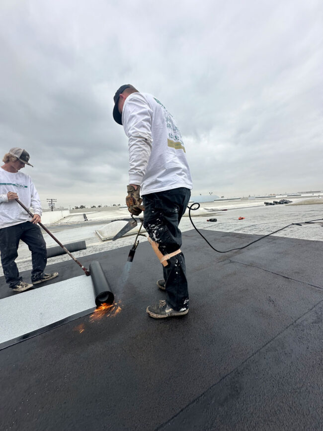 Commercial roof install using a blow torch.