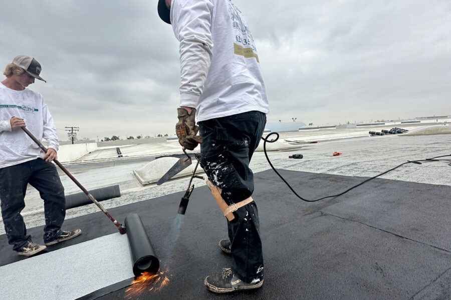 Commercial roof install using a blow torch.