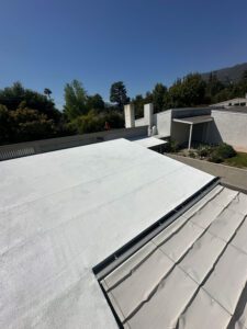 Finished side new of a residential roof painted white.