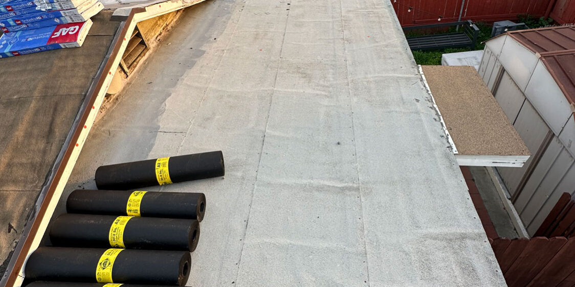Very beginnings of a roof install with plastic tarp and roofing materials shown.