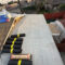Very beginnings of a roof install with plastic tarp and roofing materials shown.