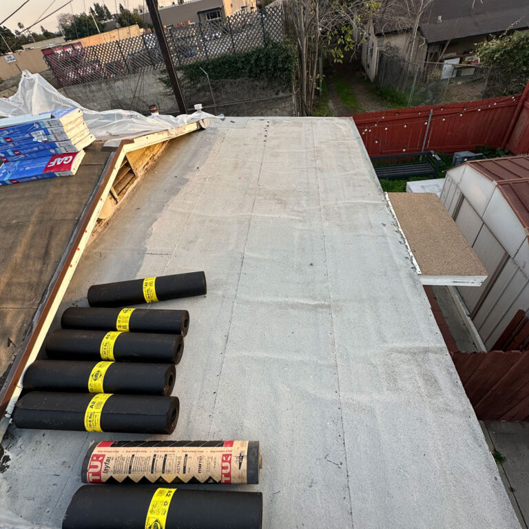 Very beginnings of a roof install with plastic tarp and roofing materials shown.