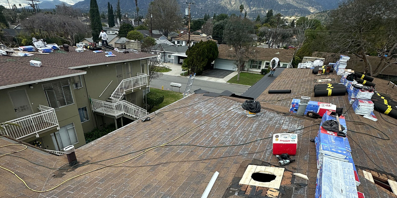 workers-on-roof Roofing materials on a roof, getting ready for installation.