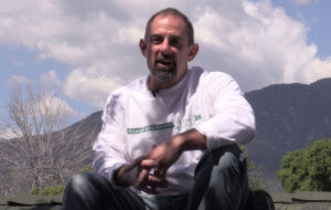 Thomas Garvey, owner of Garvey Roofing sitting on a roof.