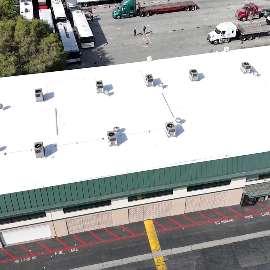 White silicone roof being installed on a commercial building.
