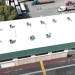 White silicone roof being installed on a commercial building.