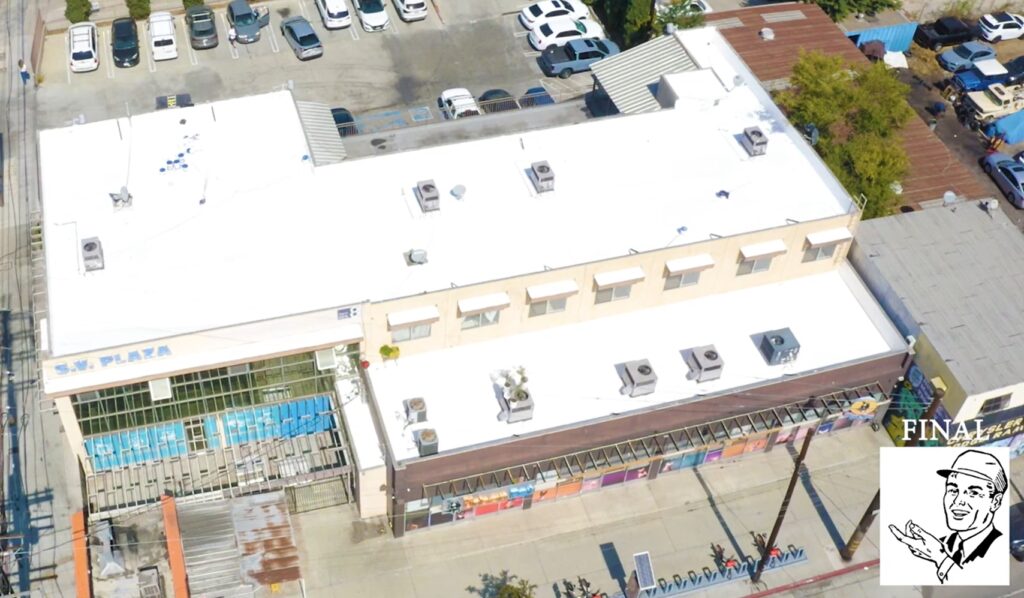 White silicone roof being installed on a commercial building.