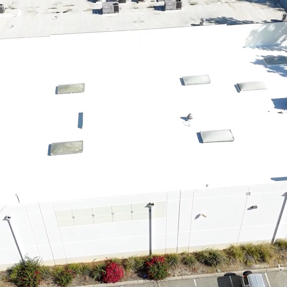 White silicone roof being installed on a commercial building.